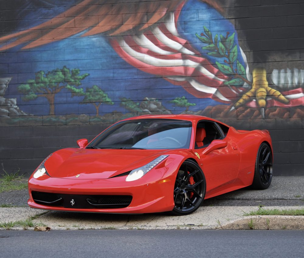 Red 2011 Ferrari 458 Italia parked in front of a mural